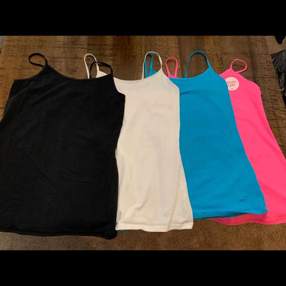 4 piece set of justice tank tops including white, black, pink, and blue.